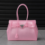 Sac Jelly Firkin Croco Candy rose bonbon effet croco posé au sol, vue studio devant un rideau métallique noir