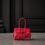 Mini sac Jelly Firkin coloris Cherry rouge cerise rempli d'objets, posé devant une porte sombre, vue alternative