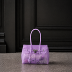 Mini sac Jelly Firkin coloris Lavender violet lavande rempli d'objets, posé devant une porte sombre, vue alternative